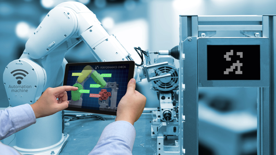 An image of a person operating industrial robot by using his tablet.